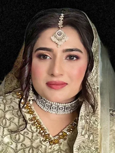 Portrait of a bride wearing traditional South Asian silver and gold bridal jewelry, with a serene expression.